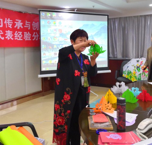 2016年度yl6809永利官网刺绣培训项目优秀学员代表杨爱凤进行剪纸展示。 2016年度yl6809永利官网刺绣培训项目优秀学员代表杨爱凤进行剪纸展示。
